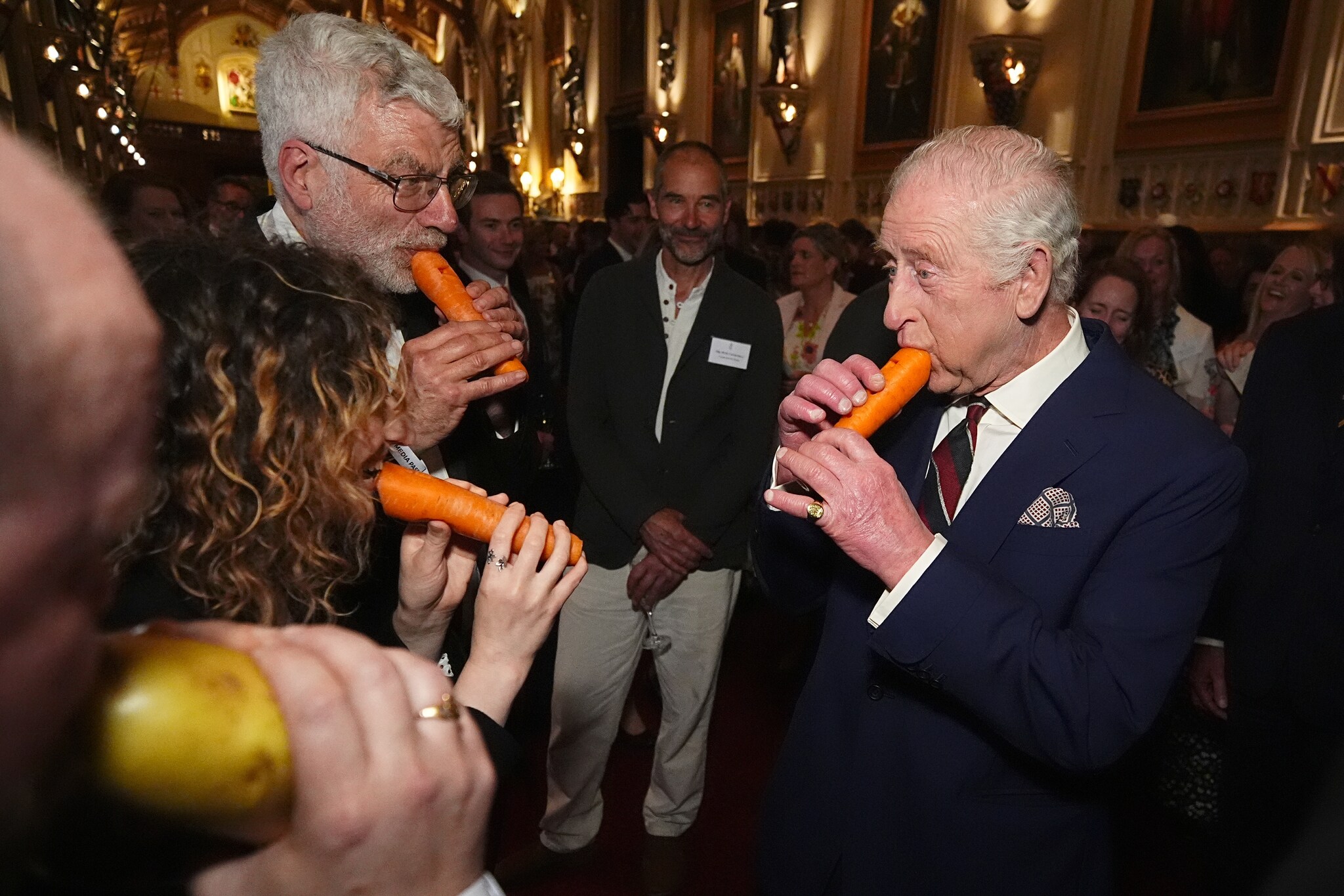 Even grinniken: koning Charles speelt de fluit, eh... wortel